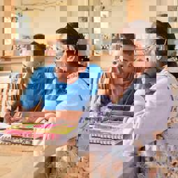 Hitesh sitting with his mum, doing paperwork